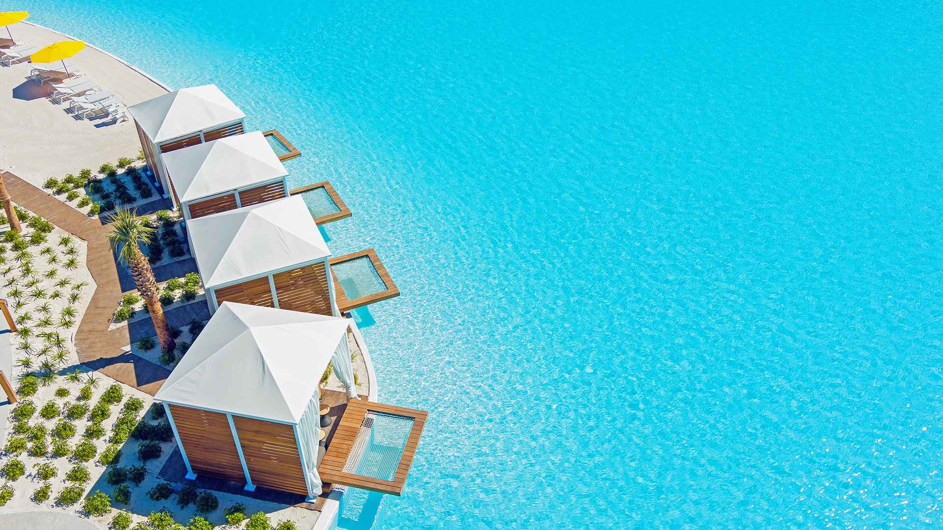 Aerial image of the private overwater cabanas on the crystal clear waters of Evermore Bay at Evermore Orlando Resort.
