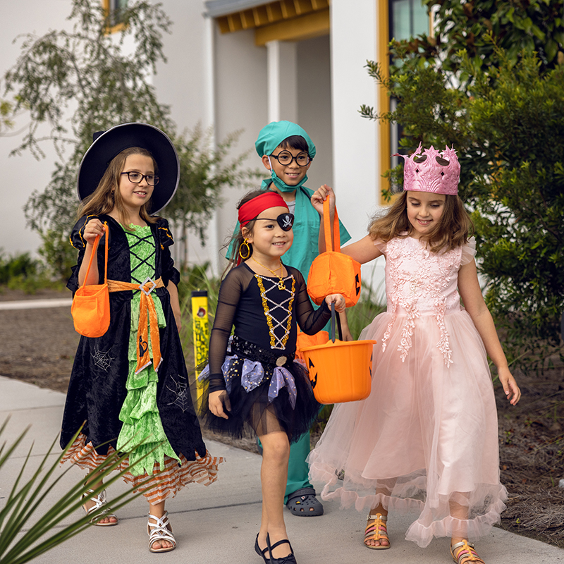 Image of children dressed in Halloween costumes while trick-or-treating at Evermore Orlando Resort.