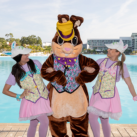 Image of the Easter Bunny with 2 greeters one either side at Evermore Orlando Resort.