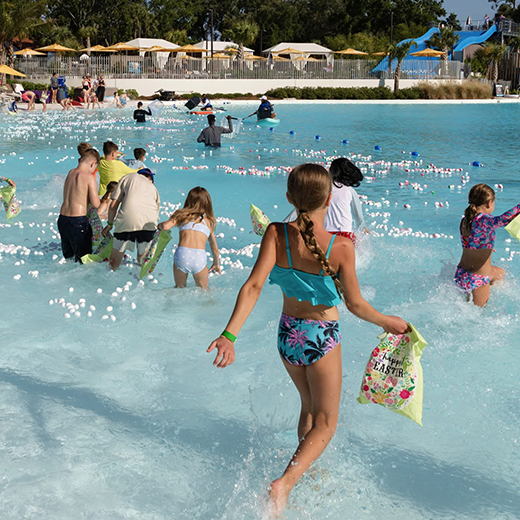 Image of guests searching for Easter eggs during the Floating Egg Hunt in Evermore Bay at Evermore Orlando Resort.