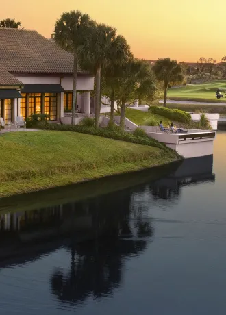 Exterior shot of Evermore Villas with Guests sitting outside on Patio overlooking the Golf Course