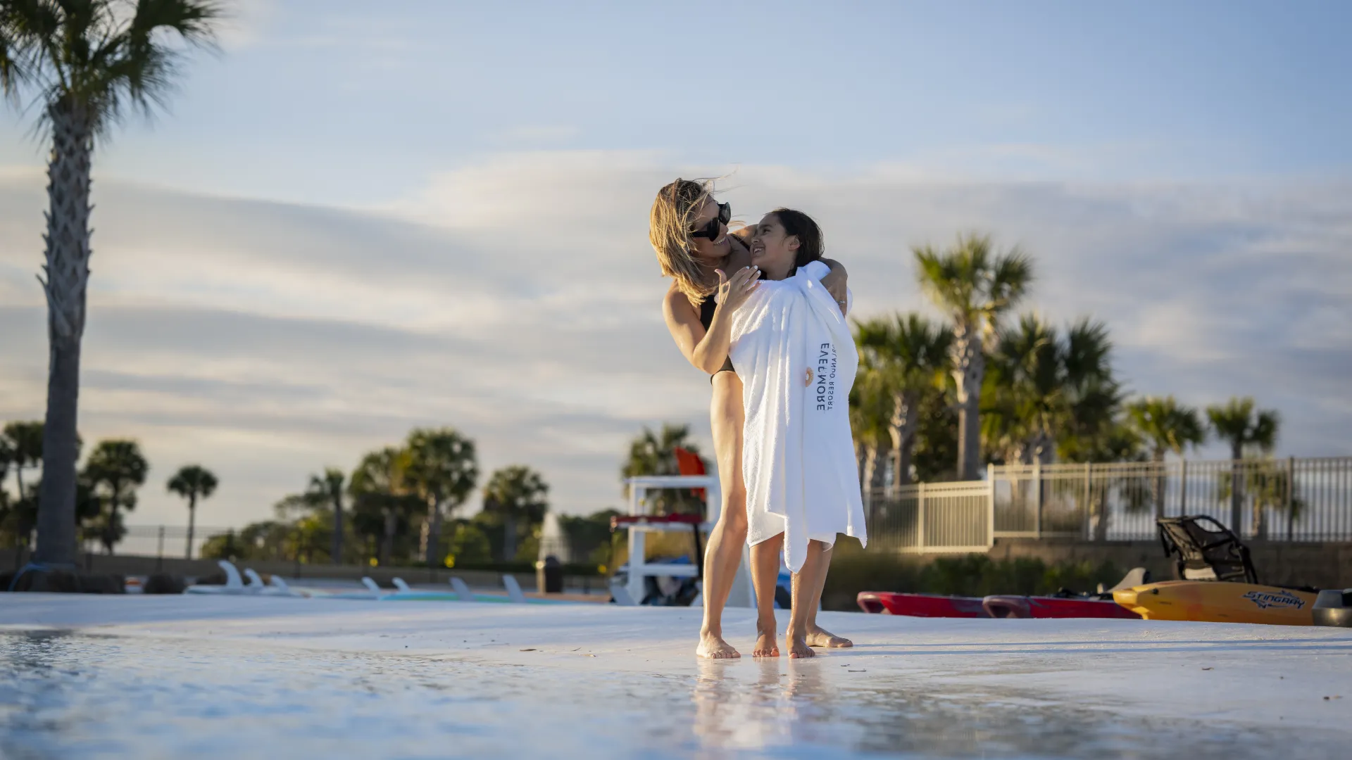 Mother Wrapping Daughter in Evermore Towel Mother Wrapping Daughter in Evermore Towel on the shores of Evermore Bay