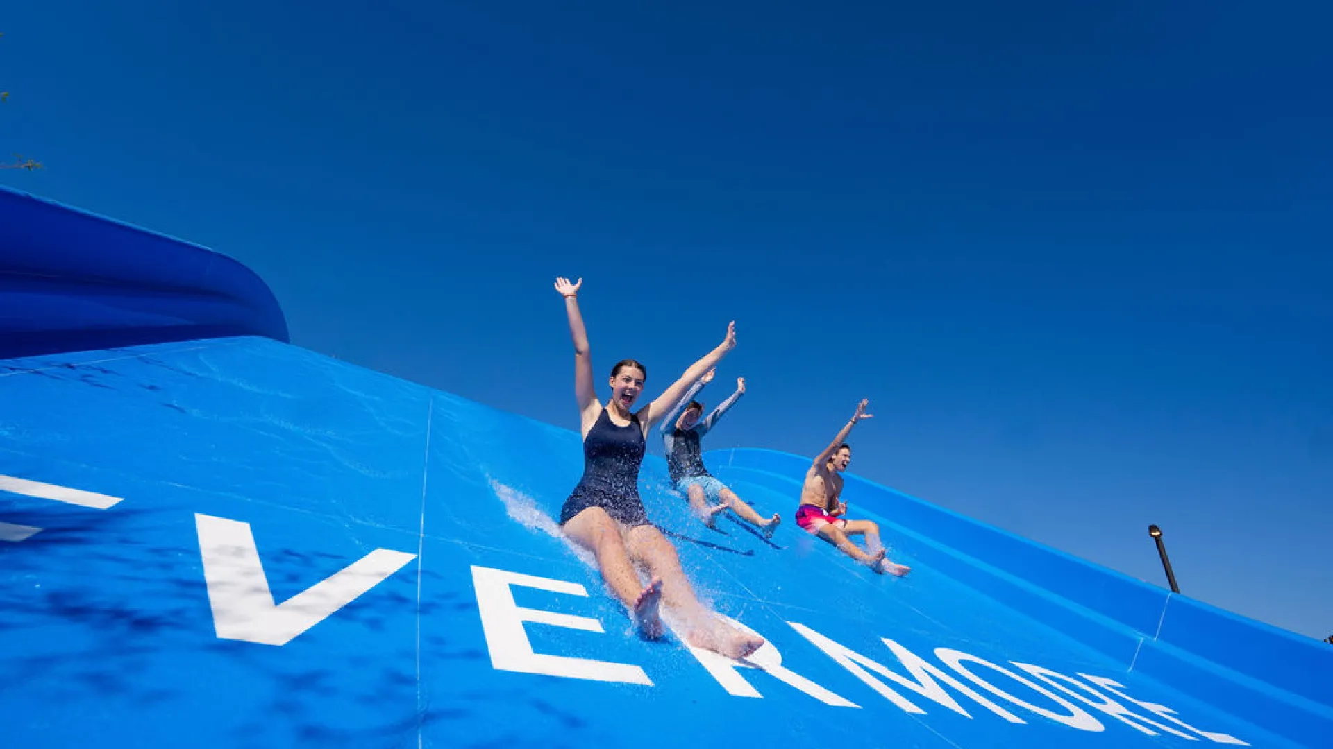 Happy guests sliding down Evermore Bay Slide