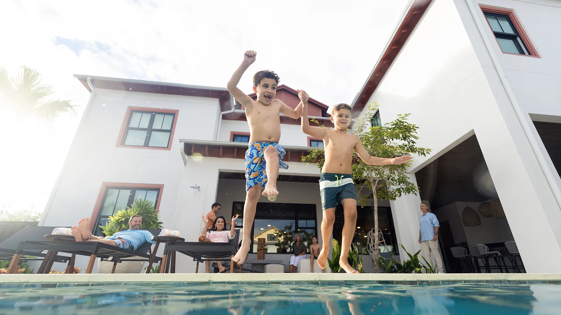 An image of two kids jumping into a private heated pool at a vacation rental house at Evermore Orlando Resort.