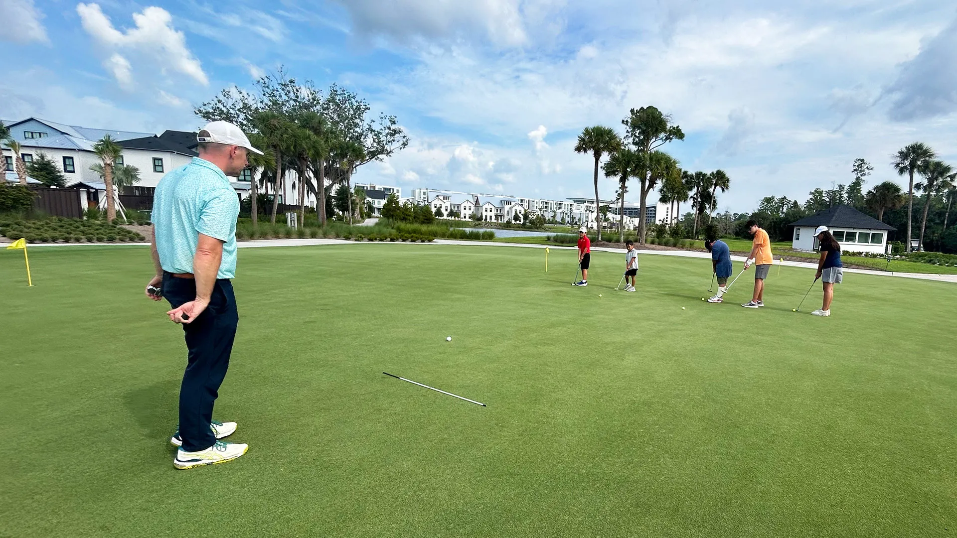 An image of a PGA instructor teaching children about putting during a Grand Cypress Golf junior camp at Evermore Orlando Resort.