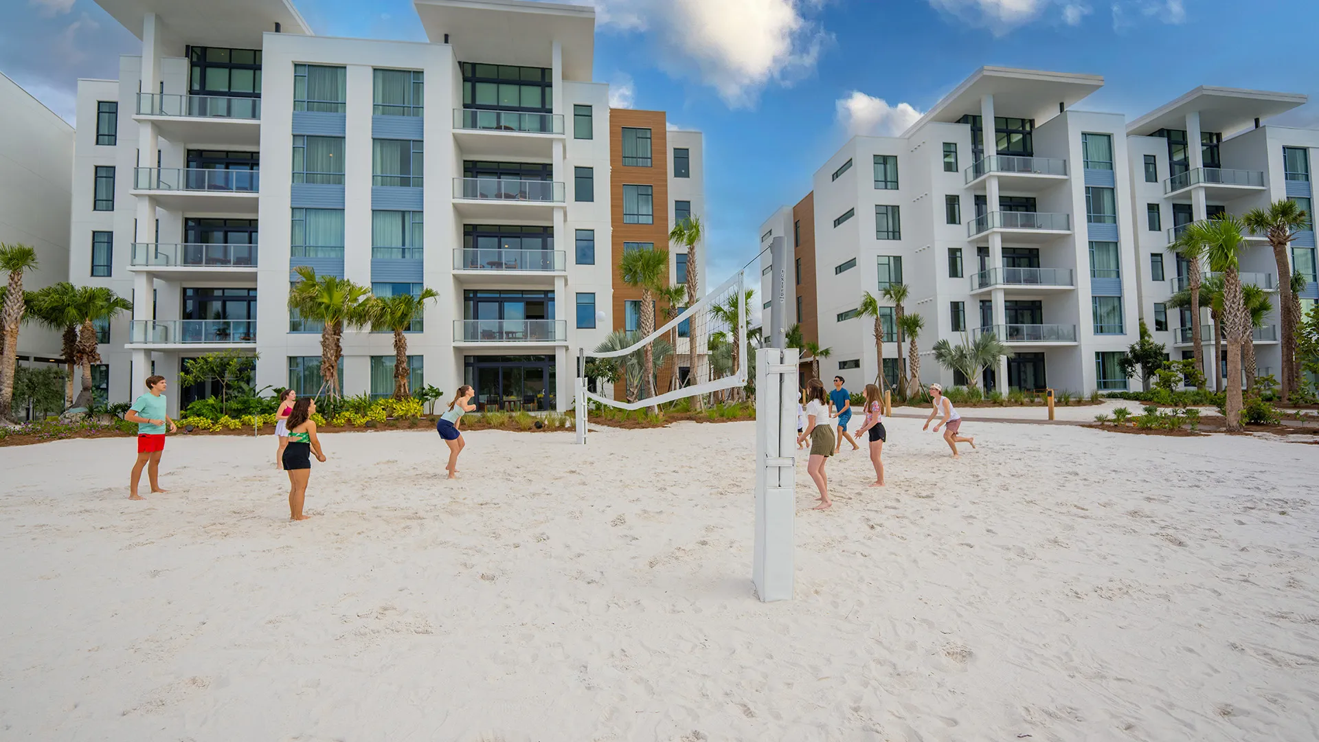 An image of guests playing beach volleyball in front of Evermore Flats.