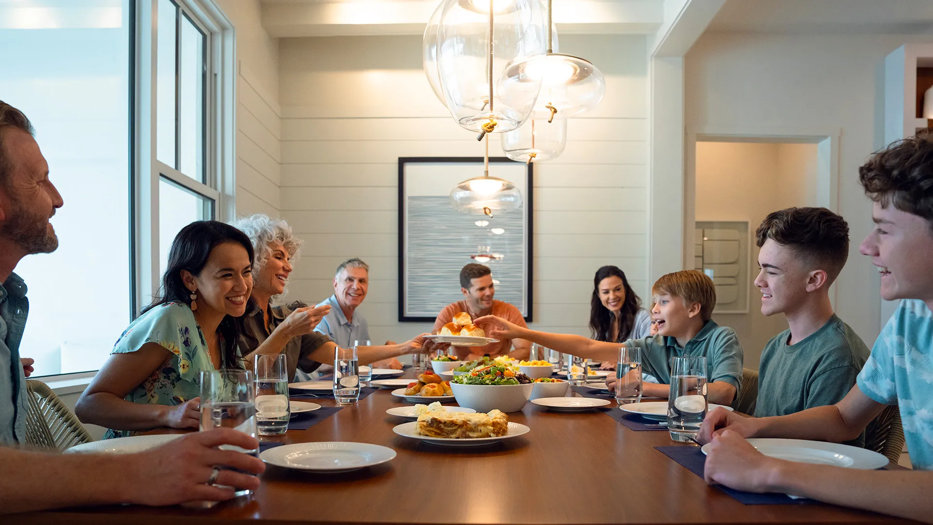 An image of a multi-generational family eating food at a table inside an Evermore House.