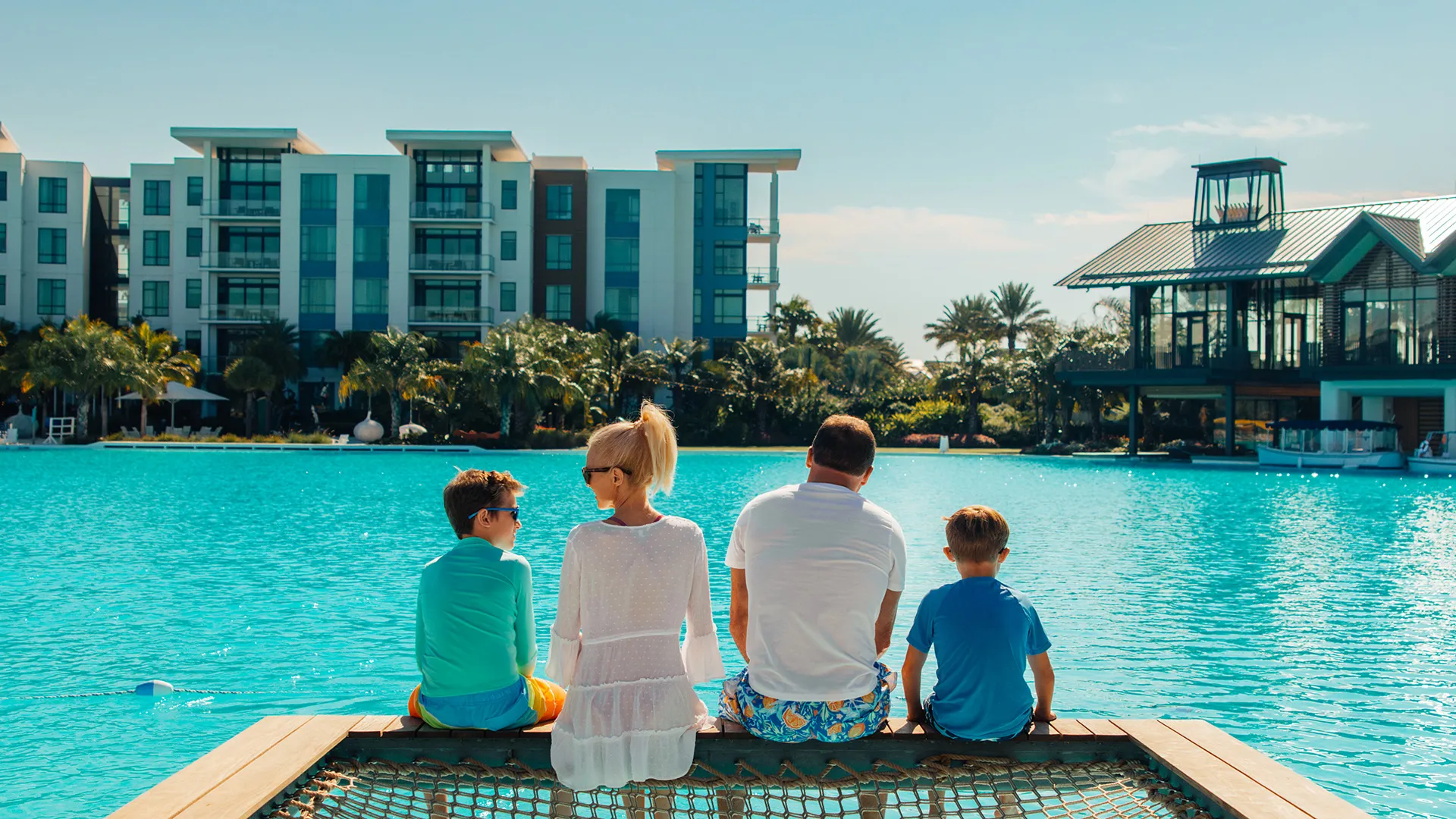 Image of a family relaxing on the overwater hammock at their private cabana on Evermore Bay at Evermore Orlando Resort.