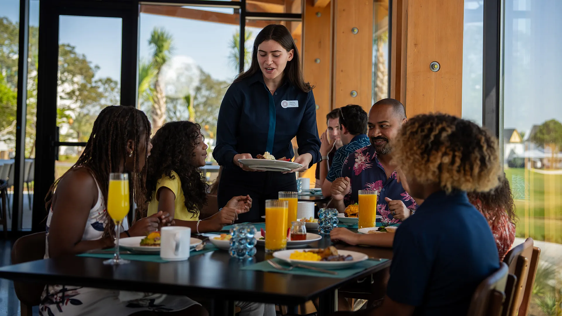 Image of a family enjoying time together while being served breakfast in Twin View Restaurant and Bar at Evermore Orlando Resort.