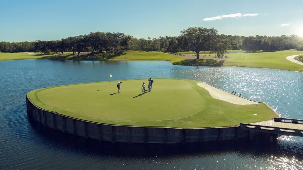 Aerial image of golfers putting on the island green par-3 on the Grand Cypress Golf Cypress Course at Evermore Orlando Resort.