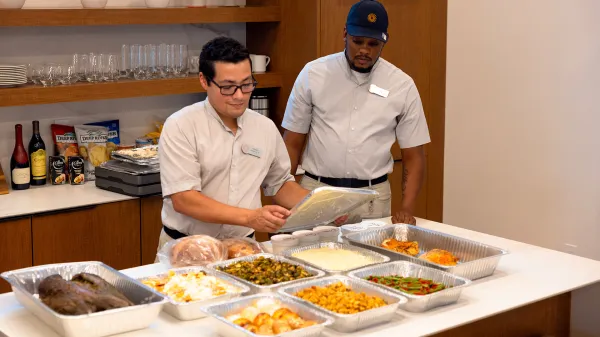 Image of Evermore team members setting up a catered meal for a private event in a vacation house at Evermore Orlando Resort.