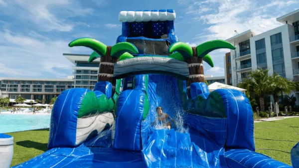 Image of a guest sliding down an inflatable obstacle course by Evermore Bay at Evermore Orlando Resort.