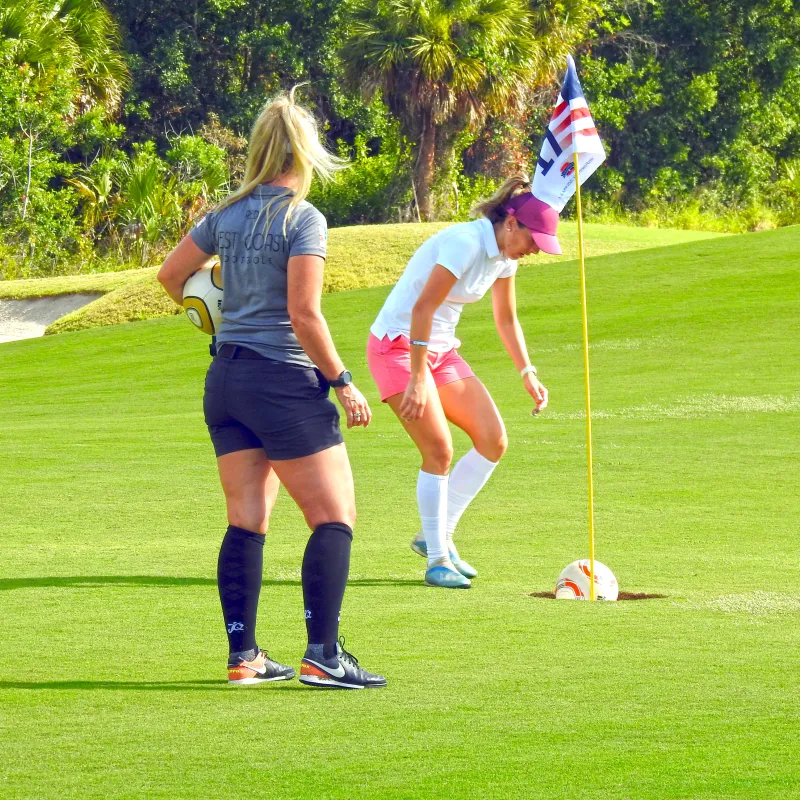 Two women playing footgolf