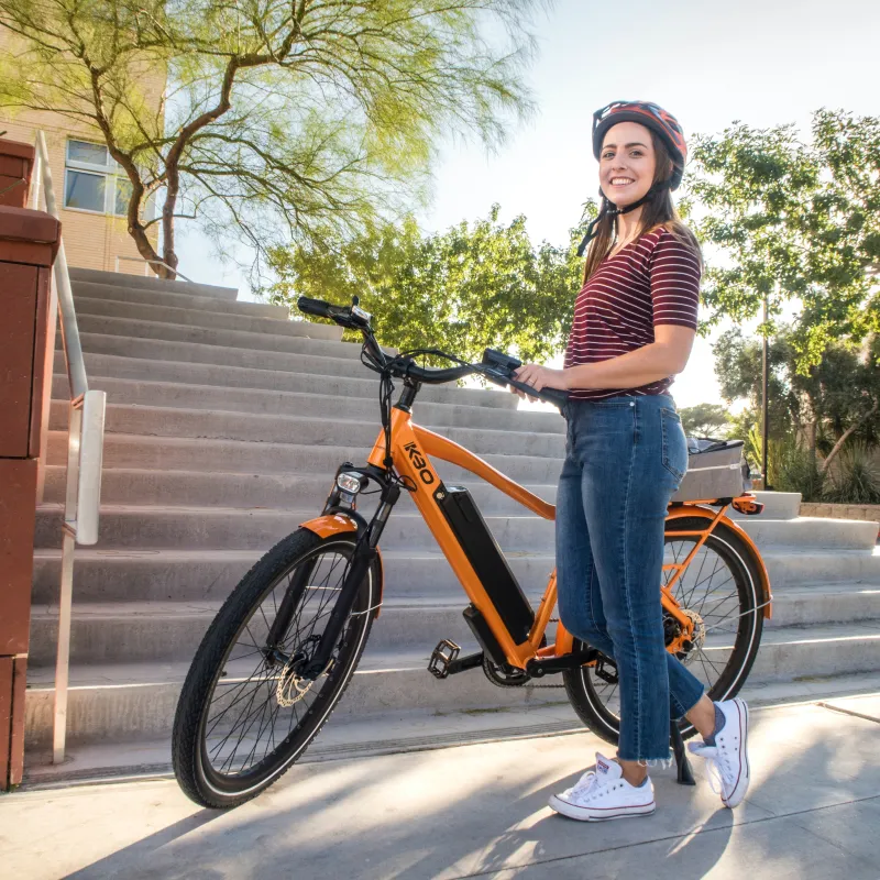 guest standing beside bicycle wearing helmet and smiling 