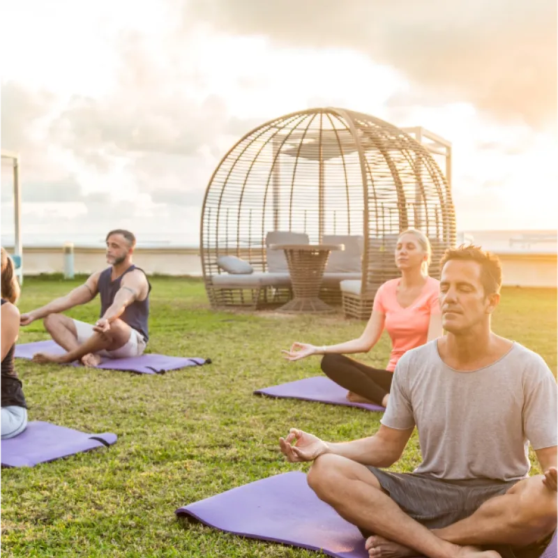 Guests enjoying yoga outdoors at sunset 