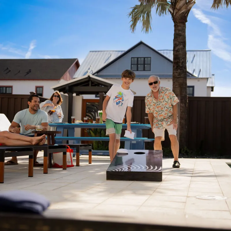 family playing cornhole in the backyard