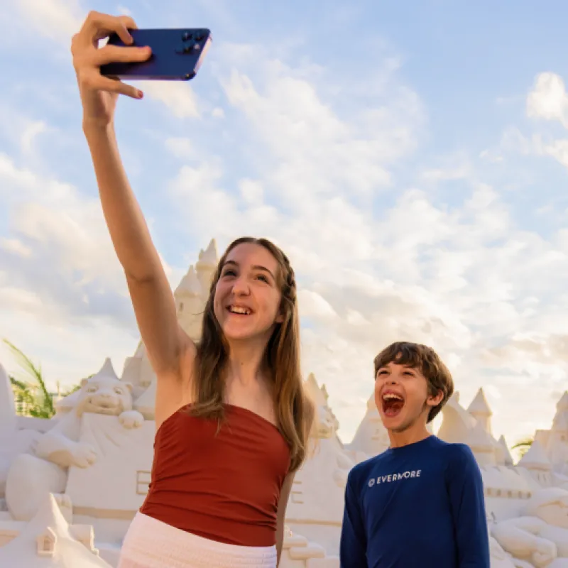 Boy and Girl taking selfie in front of Sand Castle