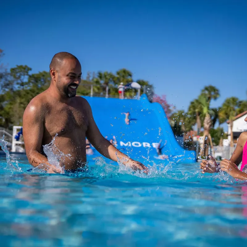Father and Daughter splashing in Slide Pool