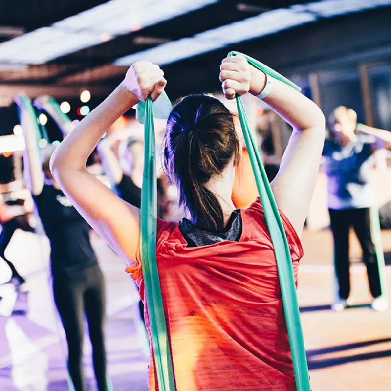 An image of a woman exercising with resistance bands in a fitness class