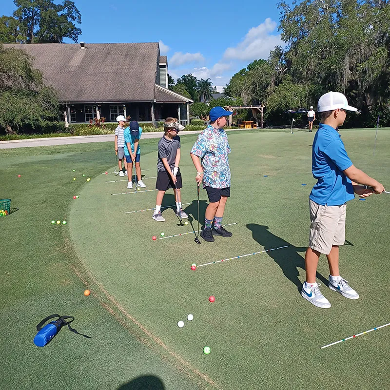 An image of children practicing putting during a Grand Cypress Golf summer camp at Evermore Orlando Resort.