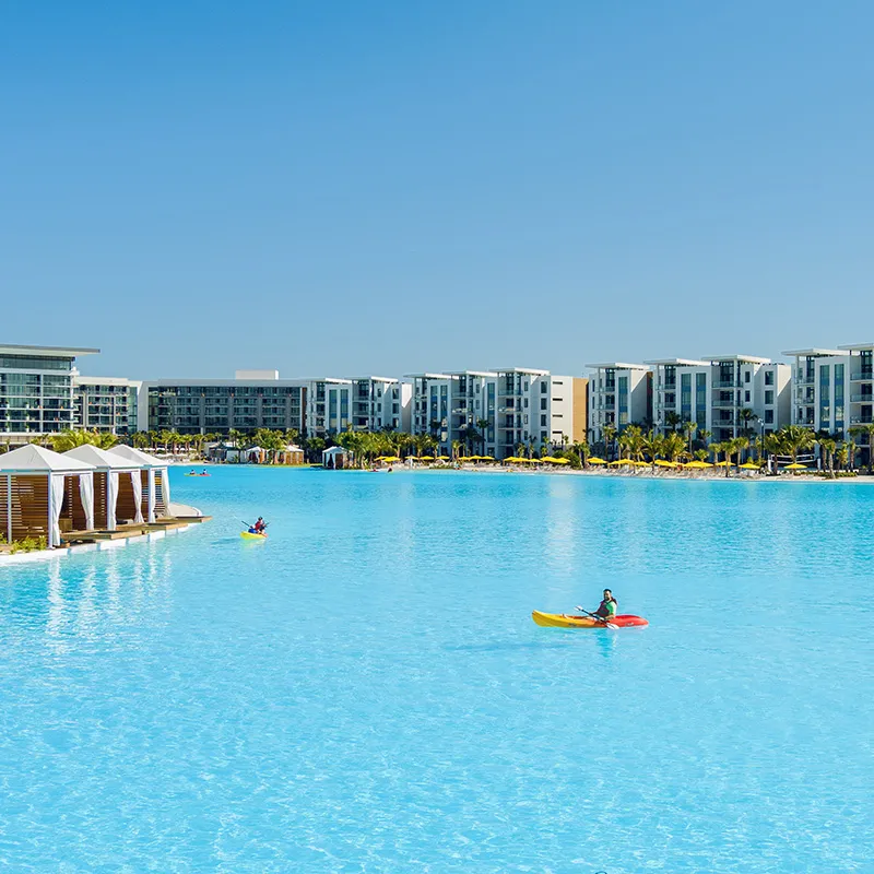 An image of kayakers enjoying the crystal clear waters of Evermore Bay near private cabanas at Evermore Orlando Resort.