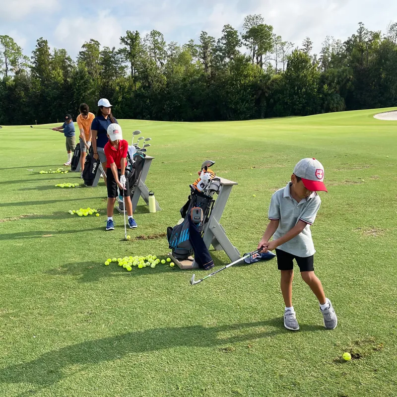 An image of children practicing chipping during a Grand Cypress Golf junior camp at Evermore Orlando Resort.