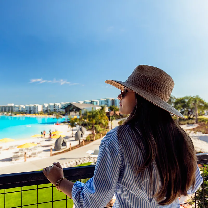 An image of a woman relaxing and recharging while on vacation and overlooking Evermore Bay at Evermore Orlando Resort.