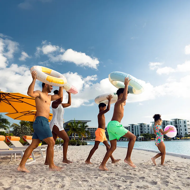 A family running with floaties to Evermore Bay at Evermore Orlando Resort.