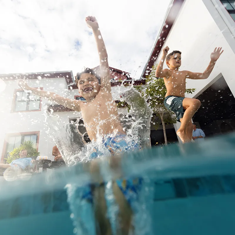 An image of two kids splashing into a private heated pool at a vacation rental house at Evermore Orlando Resort.