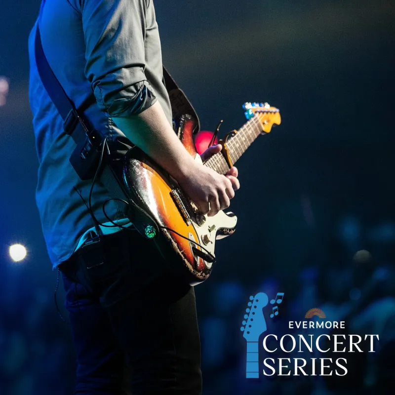 An image of a man playing an electric guitar at an outdoor concert with the Evermore Concert Series logo overlaid.