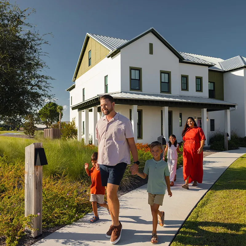 Family Walking by Their Evermore House Image of a family walking by their vacation home at Evermore Orlando Resort.