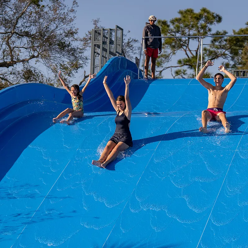Guests on Family Waterslide Image of guests laughing while sliding down the Family Waterslide at Evermore Orlando Resort.