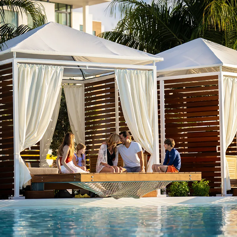 Family Relaxing in a Private Cabana on Evermore Bay Image of a family relaxing in a Private Cabana at Evermore Bay at Evermore Orlando Resort.