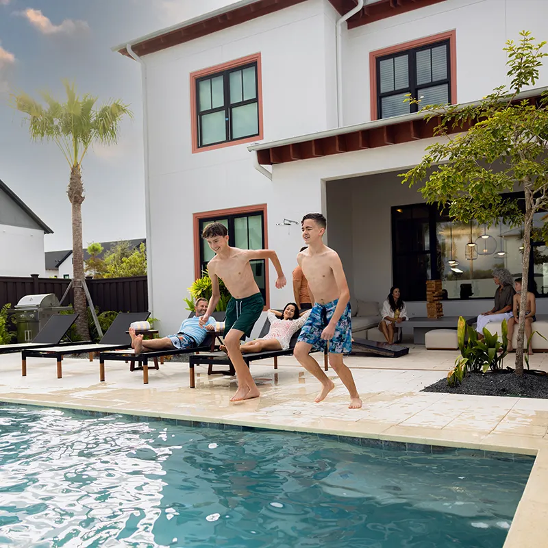 Image of a large family enjoying their private heated pool at their vacation home at Evermore Orlando Resort.