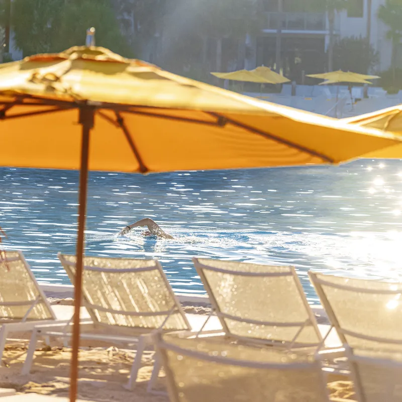 Image of a guest swimming across Evermore Bay during the Evermore Bay Open Swim experience at Evermore Orlando Resort.