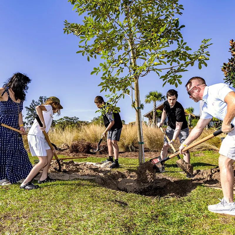 Image of a family planting their tree during the Family Tree Planting Experience at Evermore Orlando Resort.