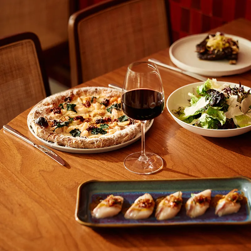 Image of Italian dishes on the table inside Sophia's Trattoria at Conrad Orlando at Evermore Orlando Resort.