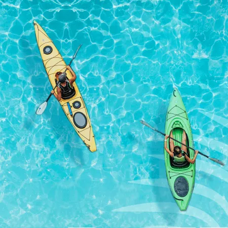 Overhead view of Adults Kayaking Evermore Bay with shadow of palm leaf in the water 