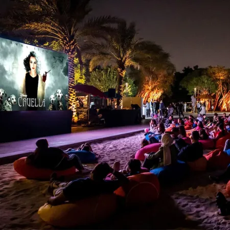 Guests enjoying outdoor movie on projector screen along the shores of Evermore bay 