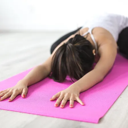 An image of a woman stretching on a yoga mat.
