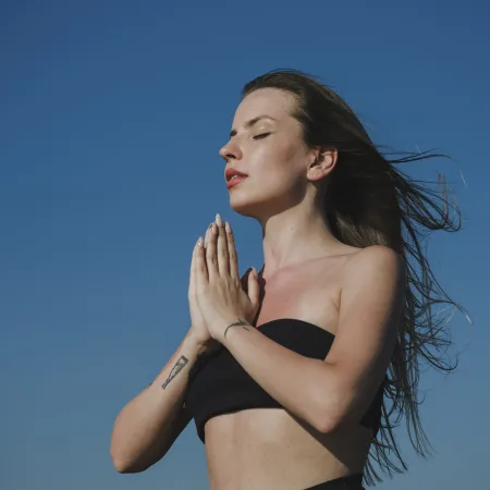An image of a woman meditating outside.