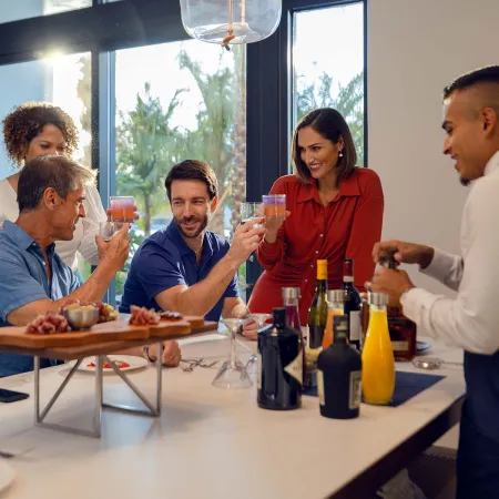 An image of two couples enjoying drinks served by a private bartender during a wedding farewell brunch at Evermore Orlando Resort.