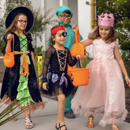 Image of children dressed in Halloween costumes while trick-or-treating at Evermore Orlando Resort.