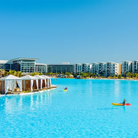 An image of Evermore Bay with Private Cabanas, Kayakers, Conrad Hotel and Evermore Flats in view.
