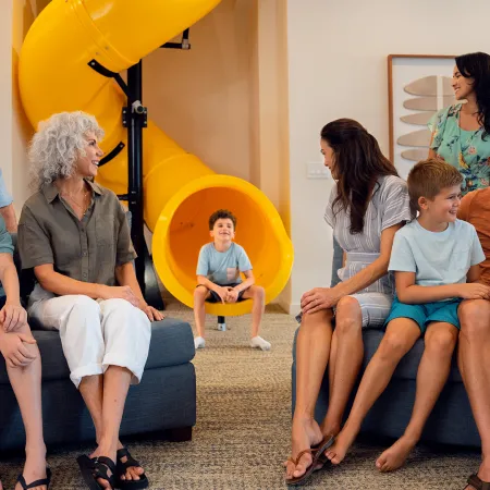 An image of a multi-generational family sitting in front of slide in an Evermore House.