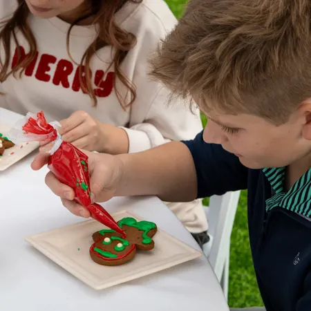 Image of kids decorating holiday cookies during Sunny's Christmas Party at Conrad Orlando at Evermore Orlando Resort.