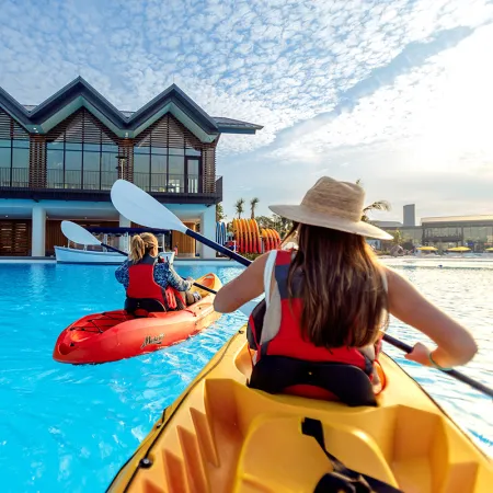 Image of guests kayaking in the crystal clear waters of Evermore Bay at Evermore Orlando Resort.