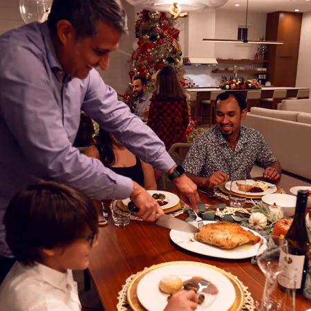 Image of a family enjoying their Evermore To Your Door holiday meal in their vacation home at Evermore Orlando Resort.