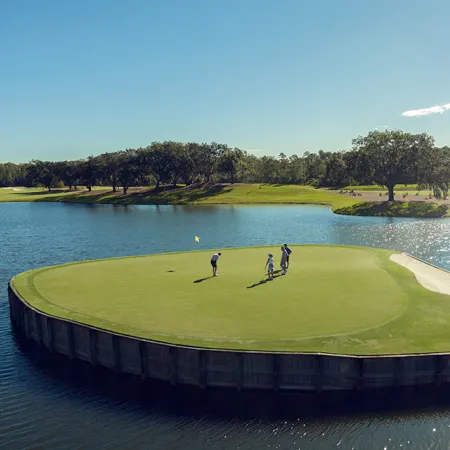 Aerial image of golfers putting on the island green par-3 on the Grand Cypress Golf Cypress Course at Evermore Orlando Resort.