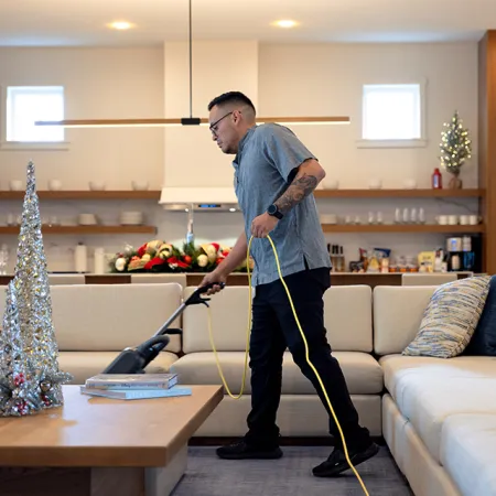 Image of a professional Housekeeping Team cleaning the living room in a vacation house at Evermore Orlando Resort.